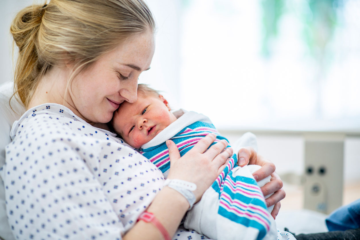 A mother cradling her newborn baby